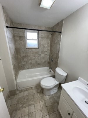 13 Pompeii Street, Unit 3 Boston, MA 02119 - Photo 8 of 9 a bathroom with a sink a toilet a mirror and a bathtub