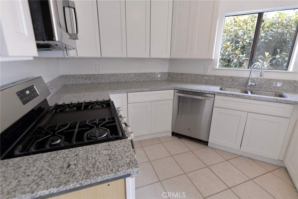 103 El Oriente, Unit 4 San Clemente, CA 92672 - Photo 6 of 19 a kitchen with a sink a stove and cabinets