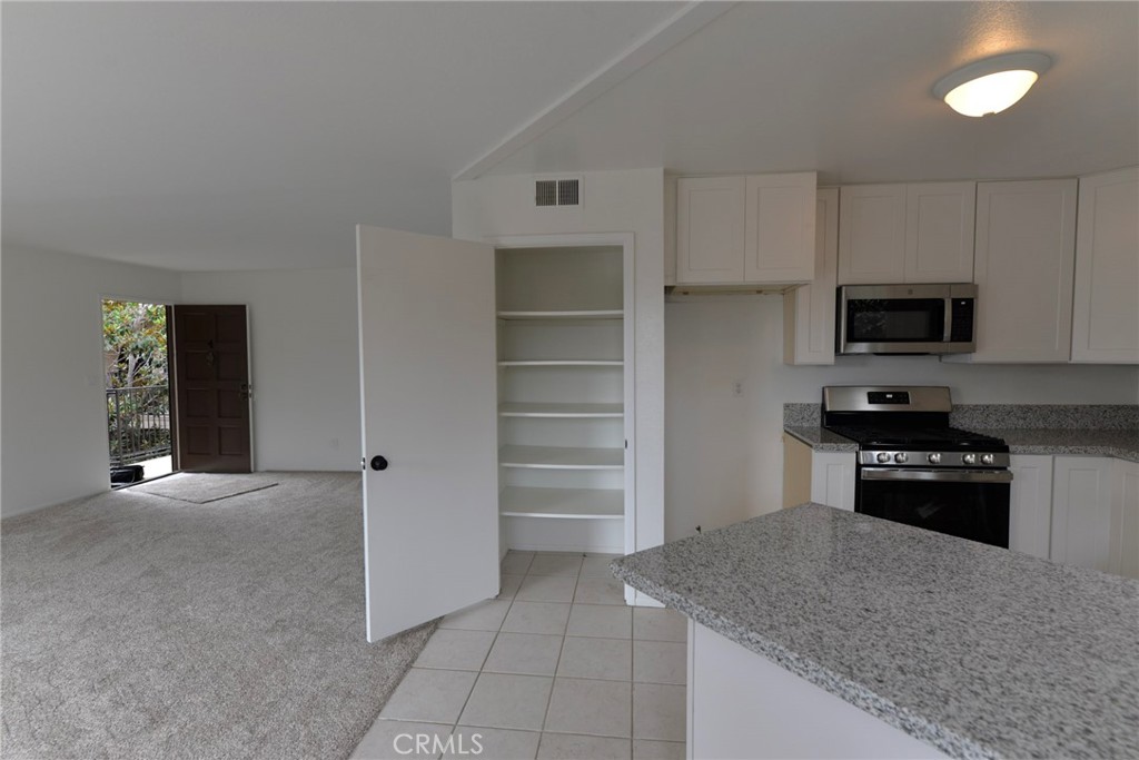 103 El Oriente, Unit 4 San Clemente, CA 92672 - Photo 7 of 19 a kitchen with granite countertop a refrigerator and a sink