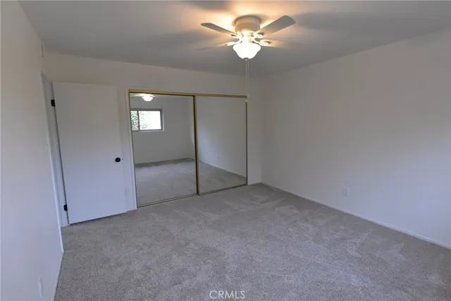 an empty room with fan and entrance