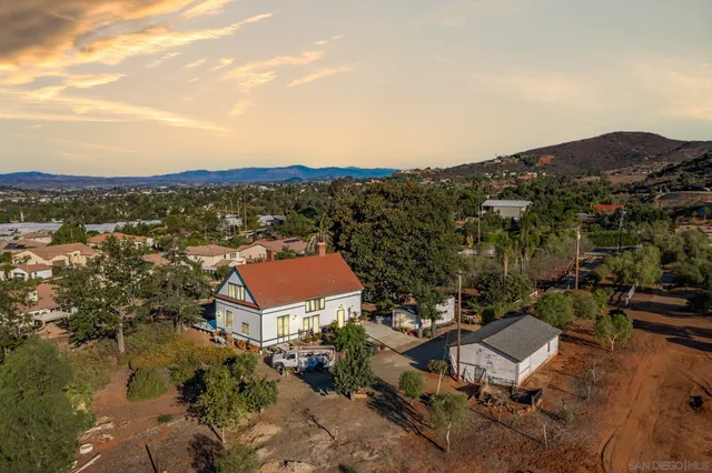 an aerial view of a house with a yard and mountain view