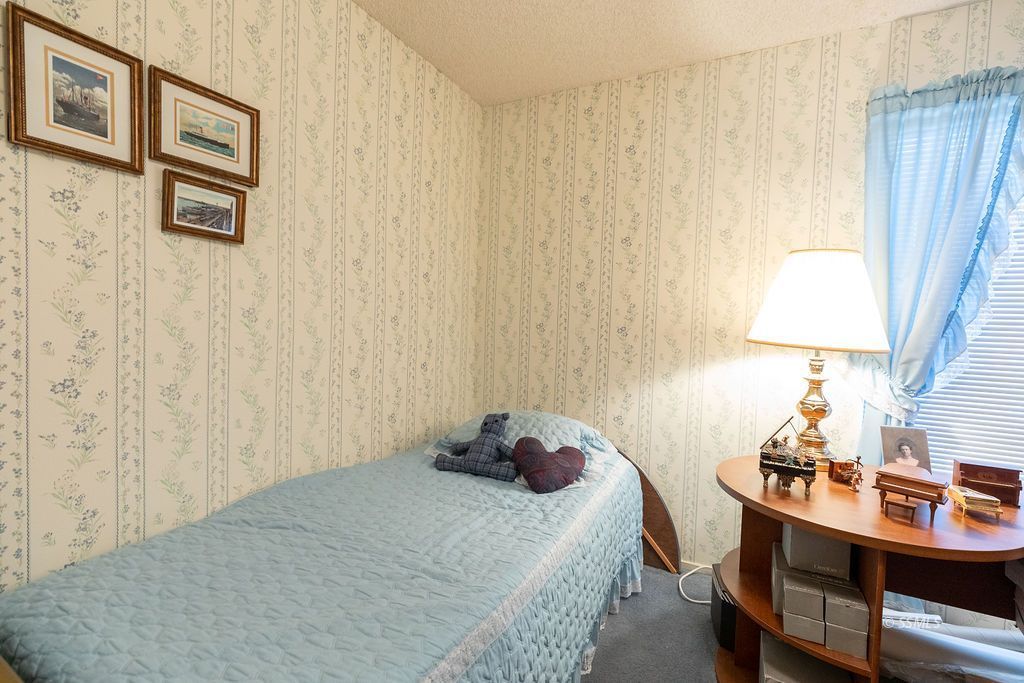 831 Peg Street Ridgecrest, CA 93555 - Photo 23 of 32 a bedroom with a bed and a table