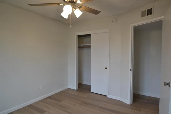 a view of an empty room with wooden floor