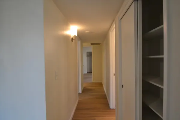 a view of a hallway with wooden floor