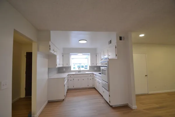 a kitchen with white cabinets and white appliances
