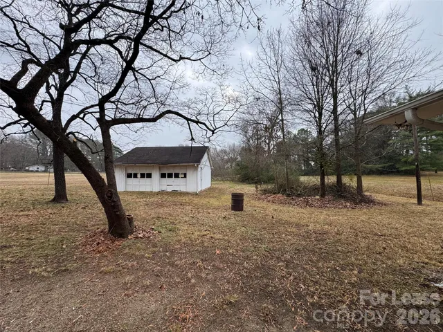 a backyard of a house with trees and wooden fence