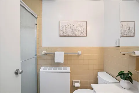 a bathroom with a toilet a sink and mirror