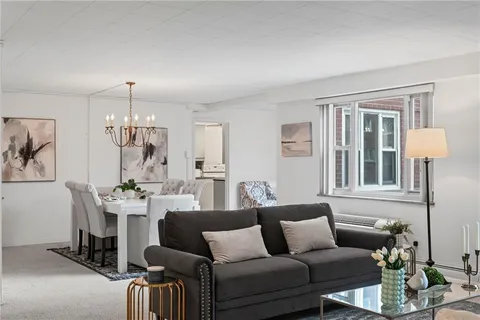 a living room with furniture and a chandelier