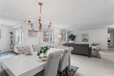 a living room with furniture a chandelier and a dining table