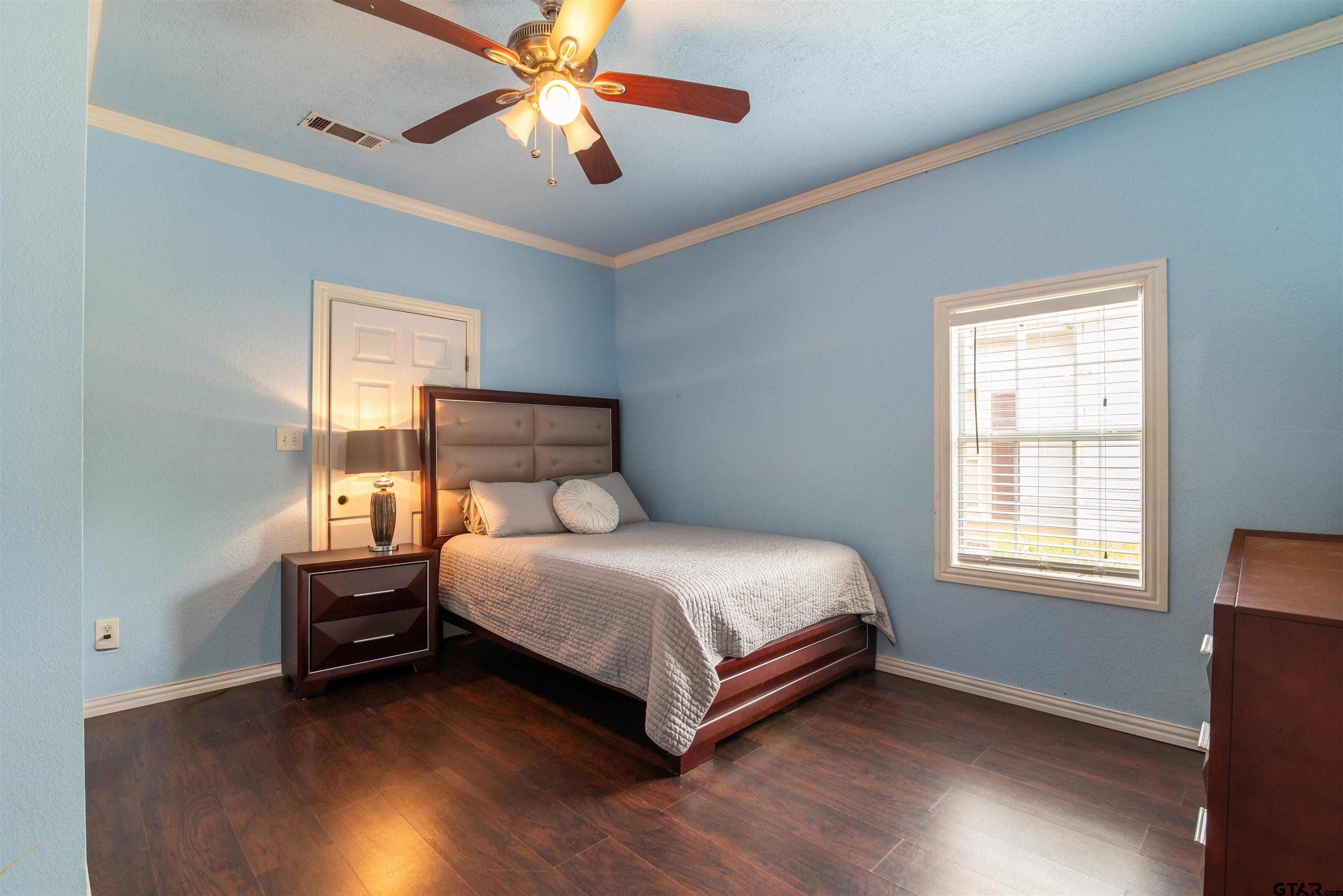 427 East Locust Street Tyler, TX 75702 - Photo 23 of 42 a bedroom with a bed and wooden floor