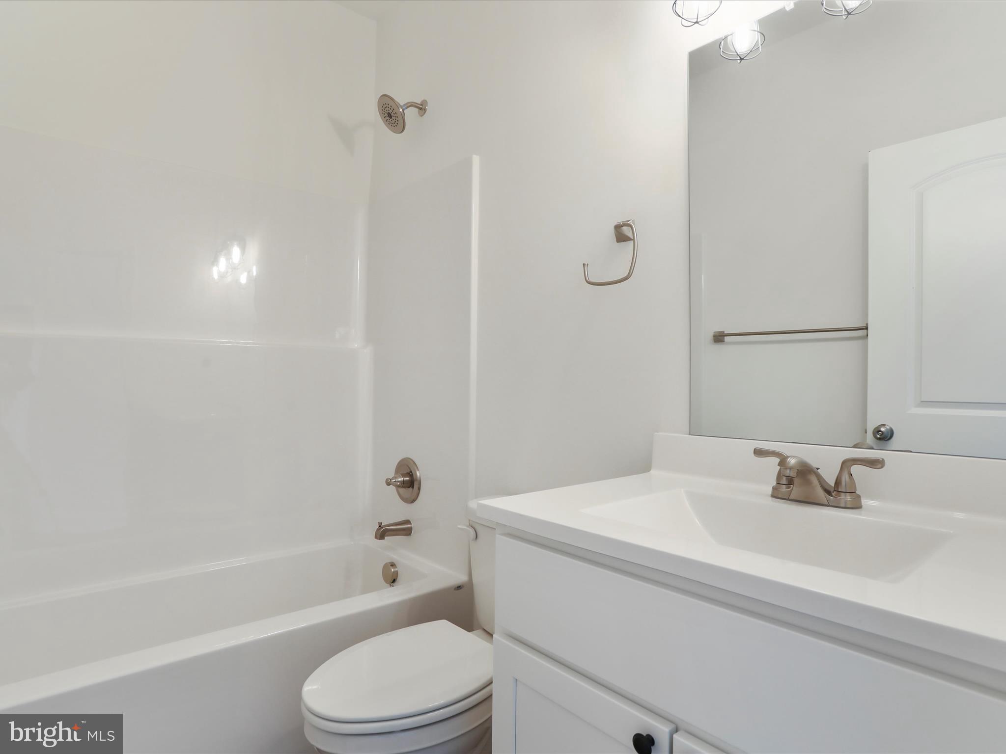117 East 7th Avenue Ranson, WV 25438 - Photo 22 of 29 a bathroom with a bathtub shower sink vanity mirror and toilet