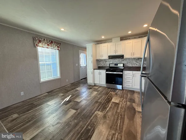 a kitchen with stainless steel appliances granite countertop a refrigerator and a stove