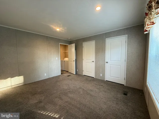 an empty room with windows and closet