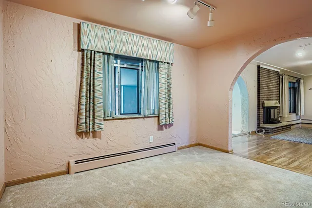 a view of an empty room with a fireplace and a window