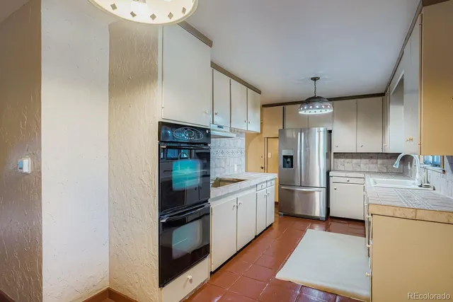 a kitchen with stainless steel appliances a refrigerator sink and cabinets