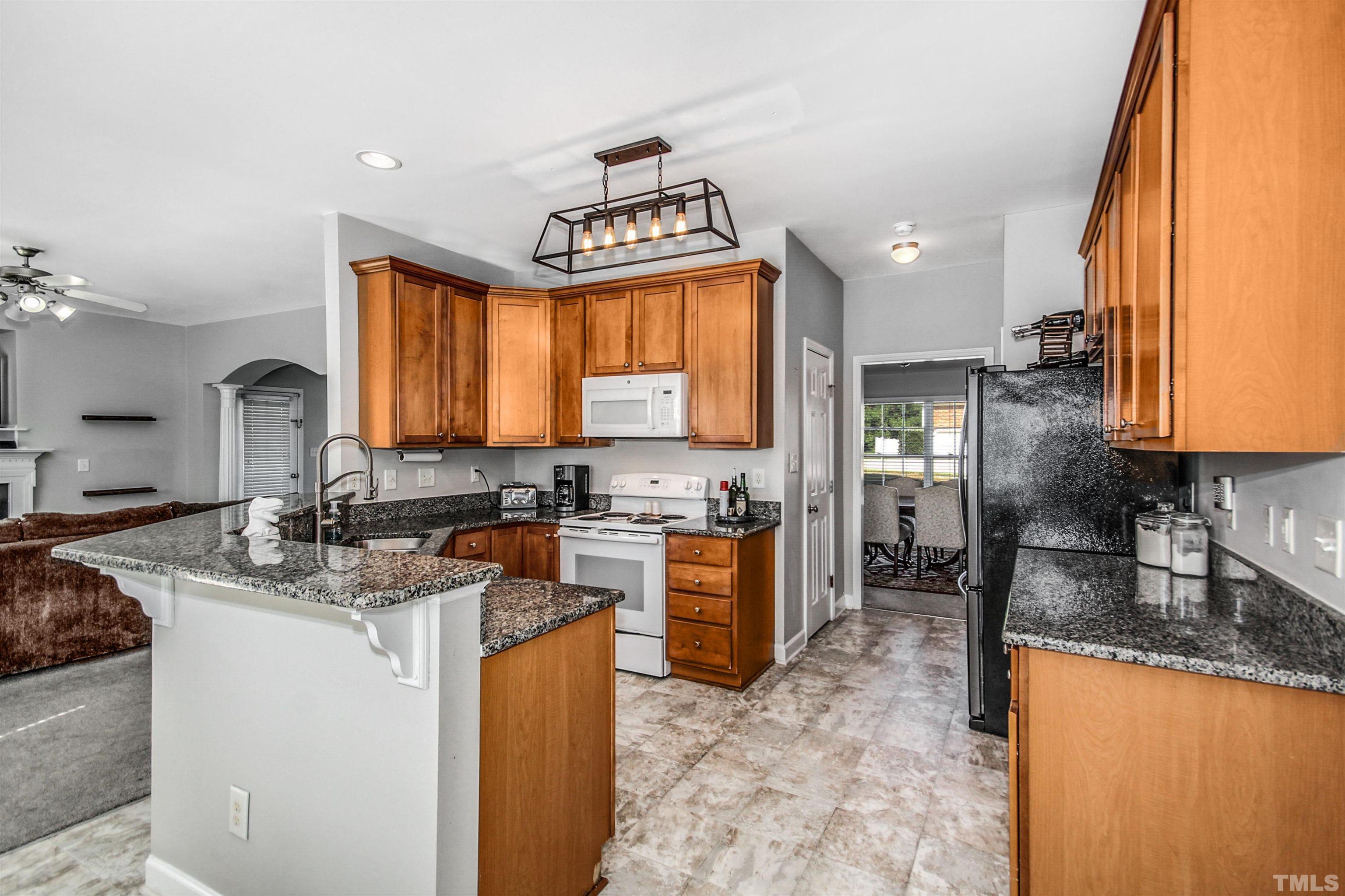 2218 Flowing Drive Raleigh, NC 27610 - Photo 11 of 27 a kitchen with refrigerator a stove a sink and a counter space