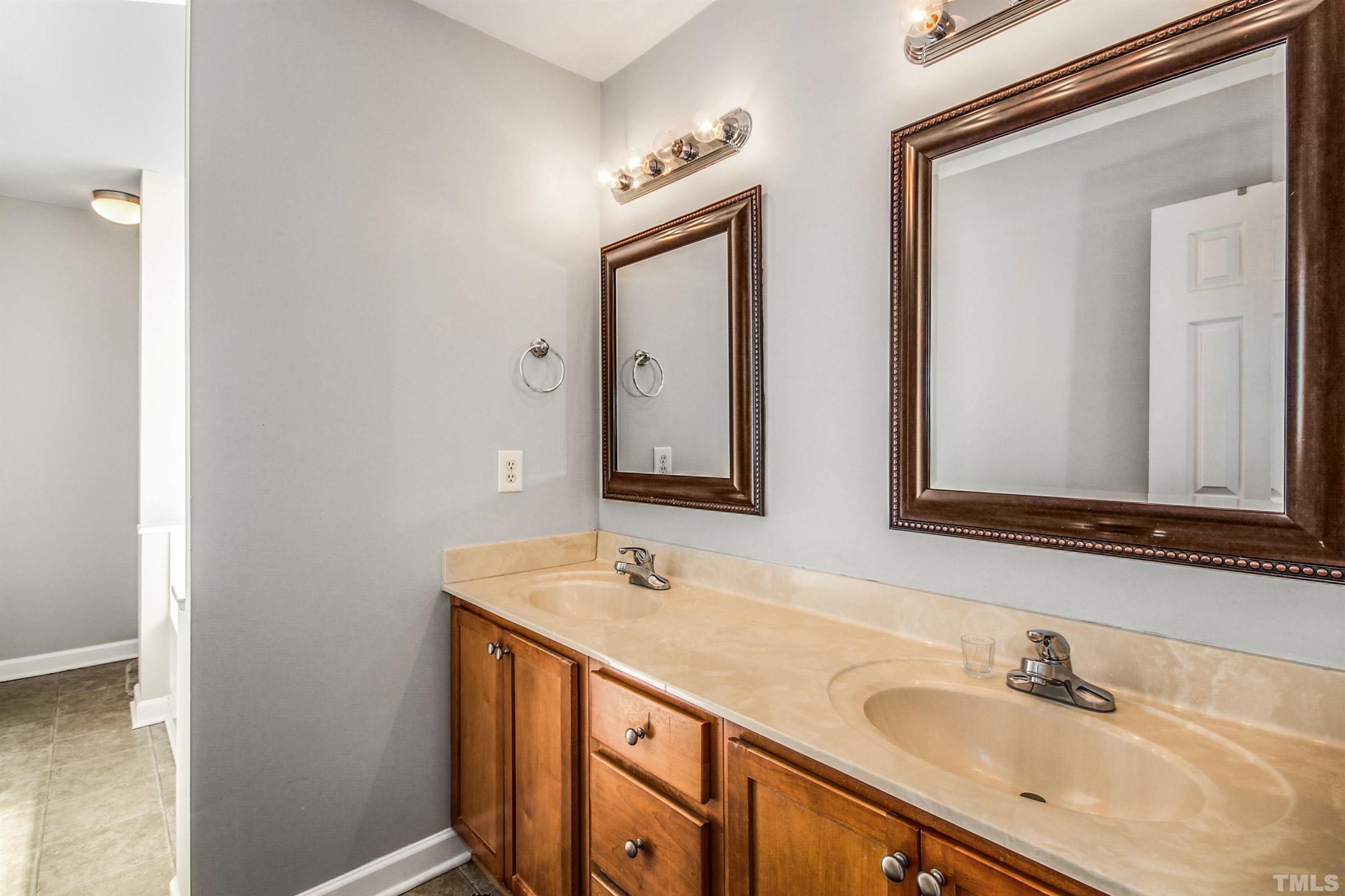 2218 Flowing Drive Raleigh, NC 27610 - Photo 16 of 27 a bathroom with 2 sink and a mirror