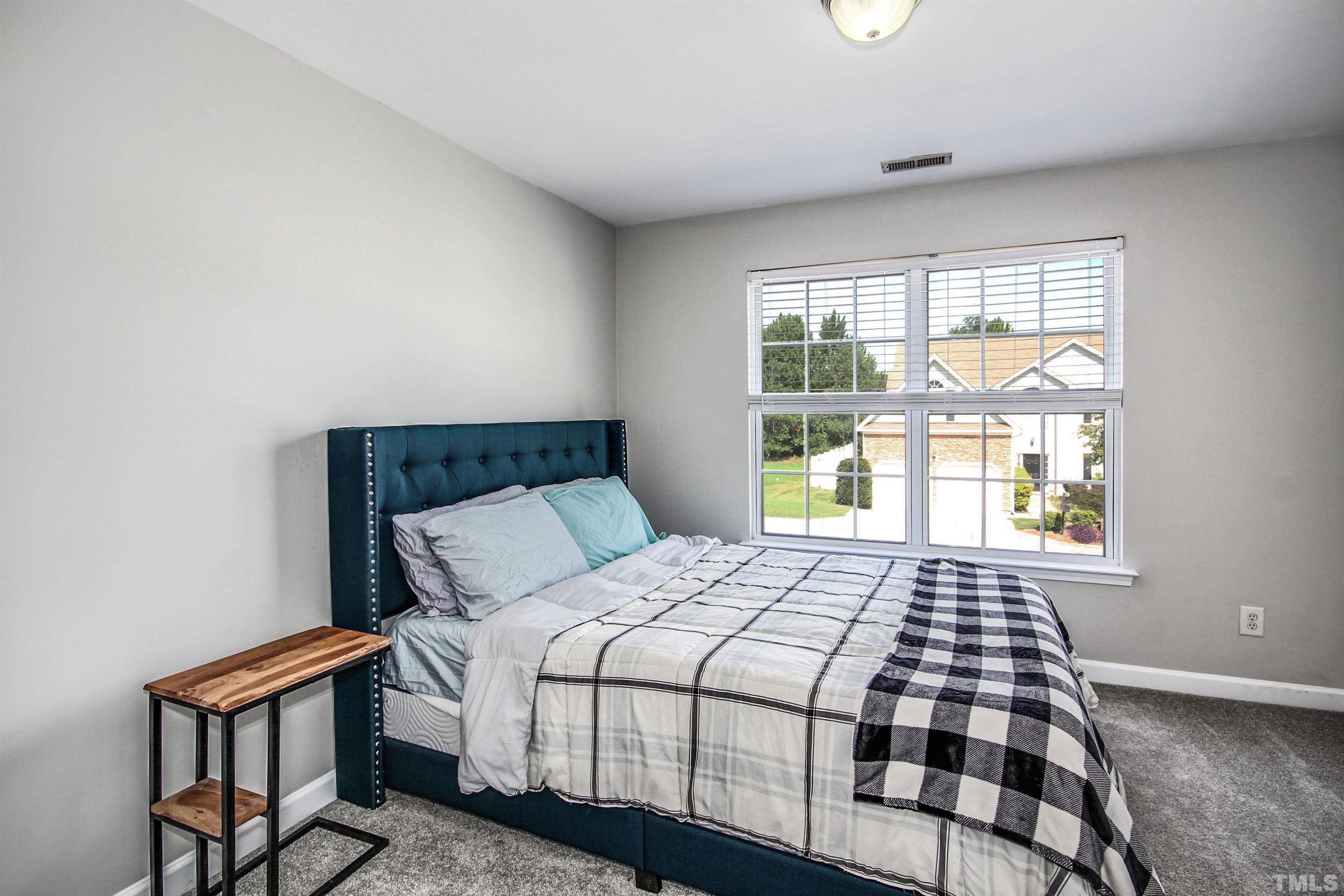 2218 Flowing Drive Raleigh, NC 27610 - Photo 18 of 27 a bedroom with a bed and wooden floor