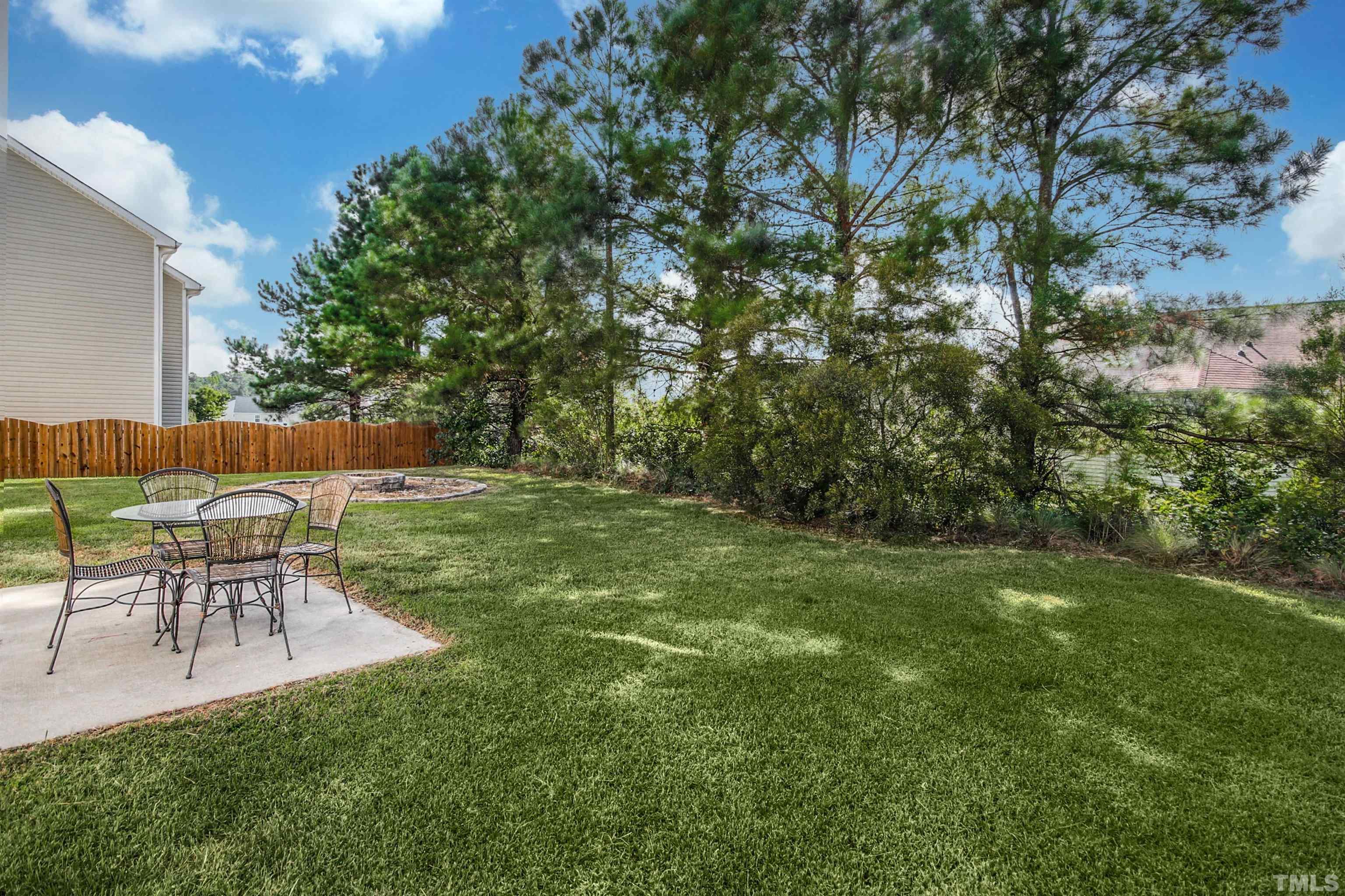 2218 Flowing Drive Raleigh, NC 27610 - Photo 23 of 27 a view of a backyard with table and chairs with wooden fence