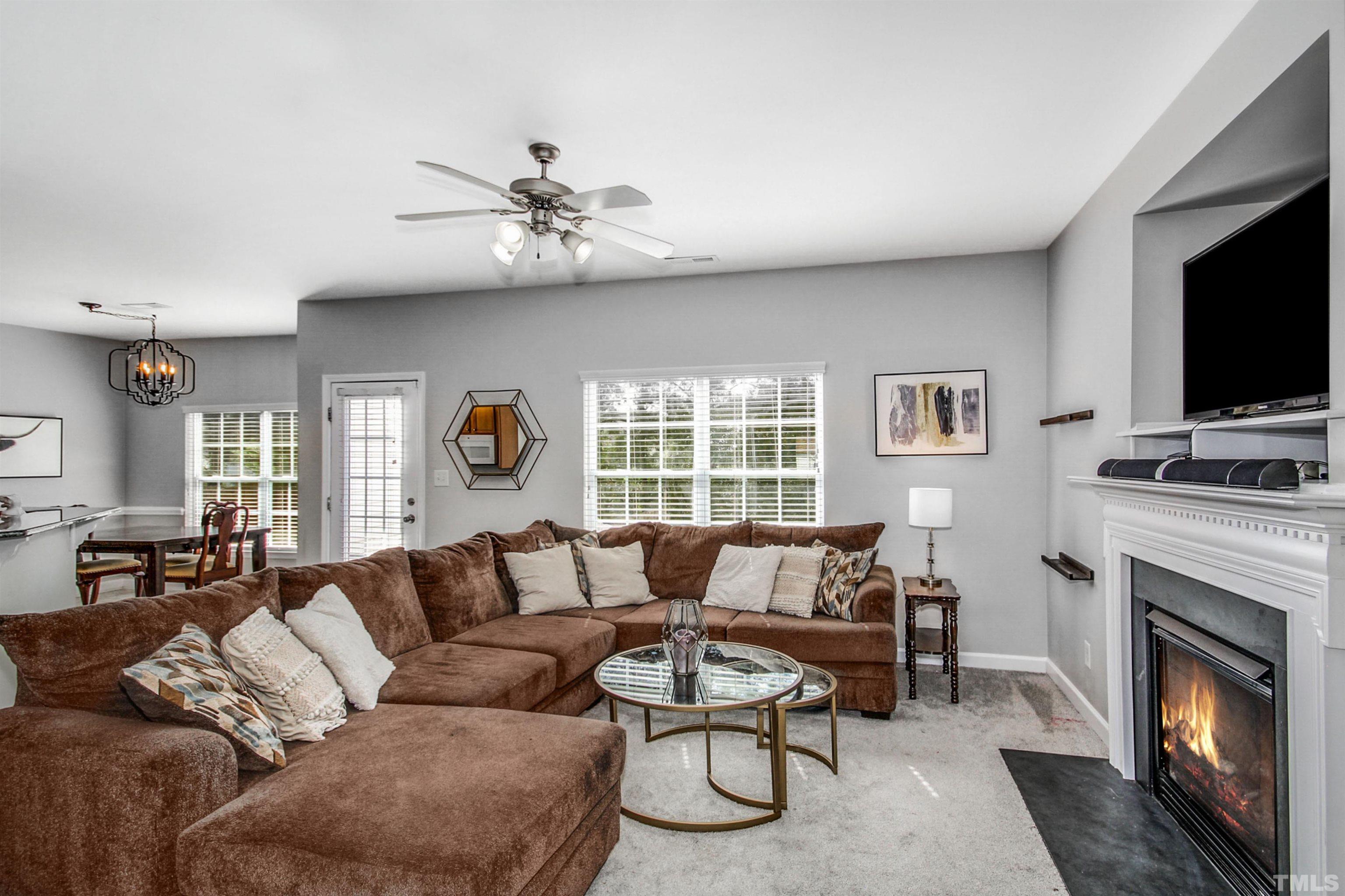 2218 Flowing Drive Raleigh, NC 27610 - Photo 8 of 27 a living room with furniture a fireplace and a flat screen tv