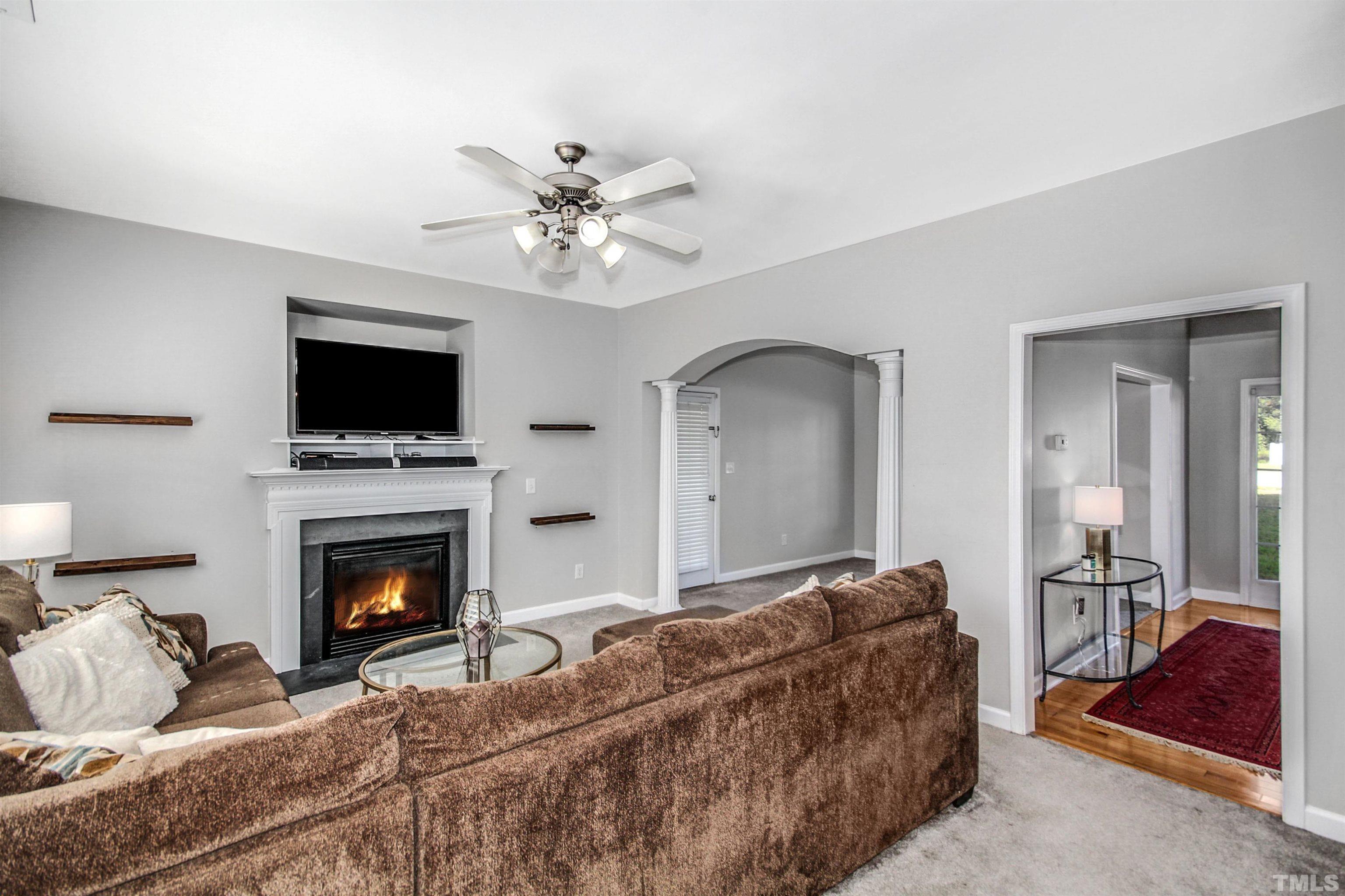 2218 Flowing Drive Raleigh, NC 27610 - Photo 9 of 27 a living room with furniture a flat screen tv and a fireplace