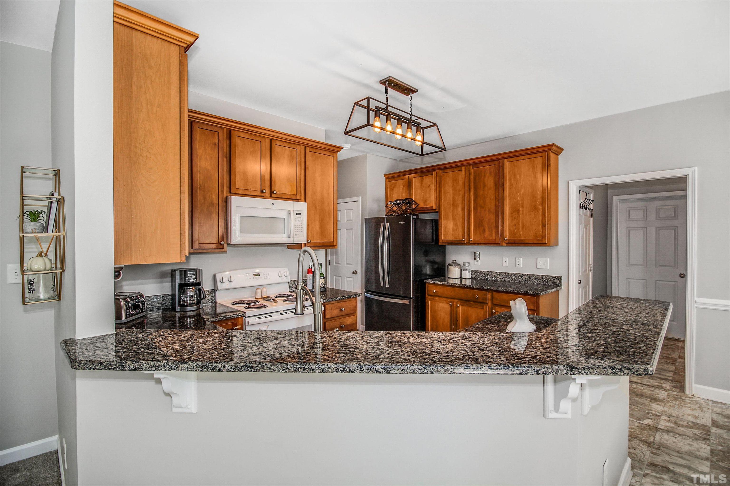 2218 Flowing Drive Raleigh, NC 27610 - Photo 10 of 27 a kitchen with stainless steel appliances granite countertop a sink stove and refrigerator