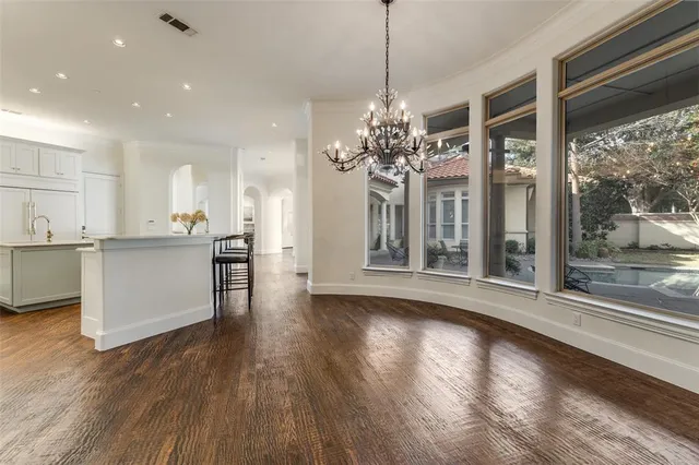 a view of a big room with wooden floor and a kitchen
