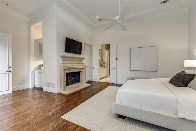 a spacious bedroom with a bed and a fireplace with wooden floor