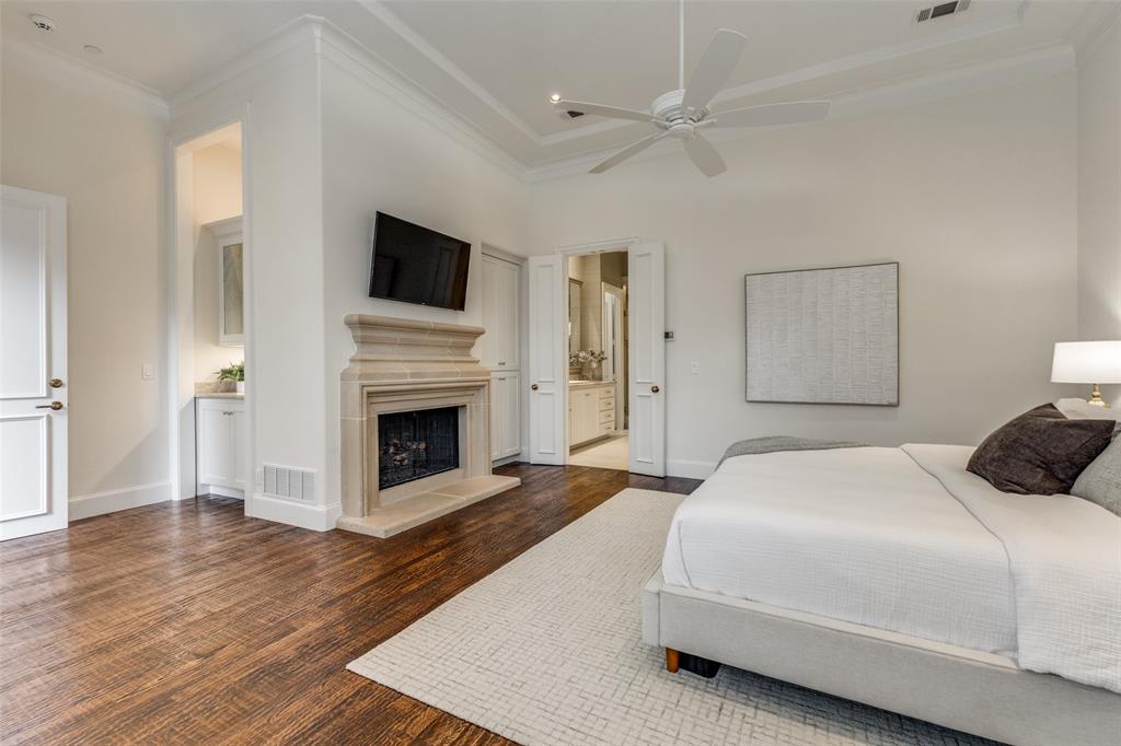 14828 Bellbrook Drive Addison, TX 75254 - Photo 21 of 36 a spacious bedroom with a bed and a fireplace with wooden floor