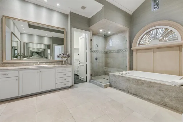a spacious bathroom with a double vanity sink a large mirror and a bathtub