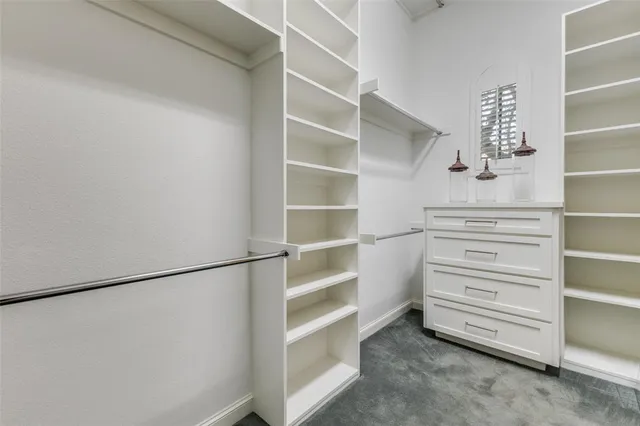 a view of walk in closet with empty racks