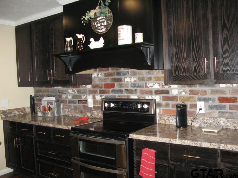 15210 County Road 285 Tyler, TX 75707 - Photo 19 of 33 a kitchen with stainless steel appliances granite countertop a stove and cabinets