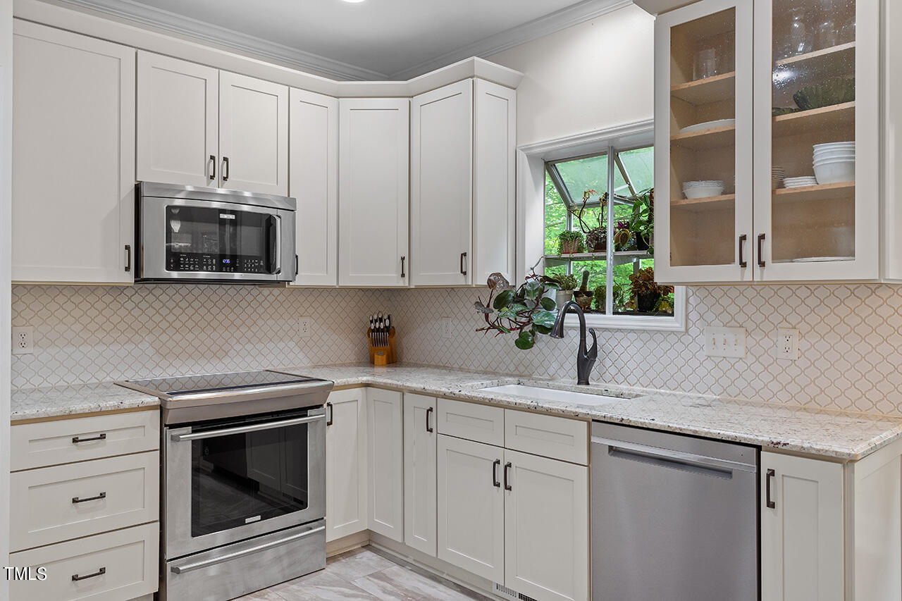 2604 Clerestory Place Raleigh, NC 27615 - Photo 20 of 37 a kitchen with white cabinets and white appliances