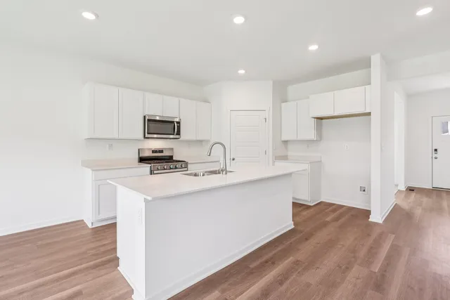 a kitchen with a sink a stove and cabinets