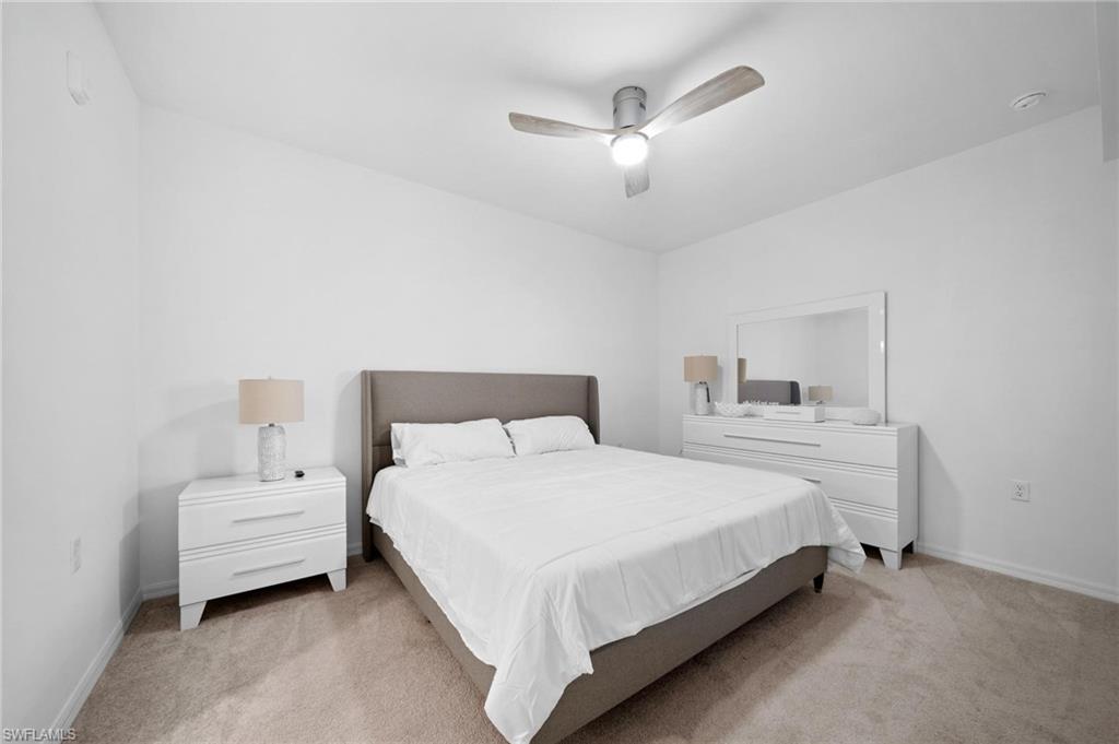 43997 Boardwalk Loop, Unit 1837 Babcock Ranch, FL 33982 - Photo 12 of 26 a bedroom with a bed and a chandelier