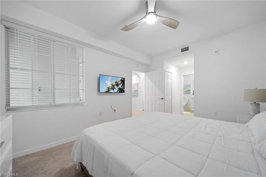 43997 Boardwalk Loop, Unit 1837 Babcock Ranch, FL 33982 - Photo 13 of 26 a bedroom with a large bed and a chandelier