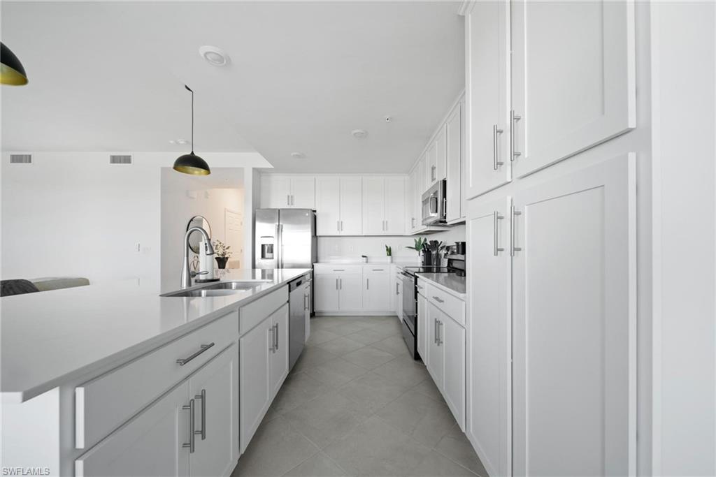 43997 Boardwalk Loop, Unit 1837 Babcock Ranch, FL 33982 - Photo 7 of 26 a kitchen with white cabinets and white appliances