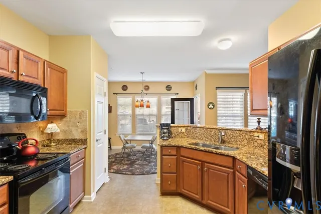 a kitchen with granite countertop a sink and a refrigerator