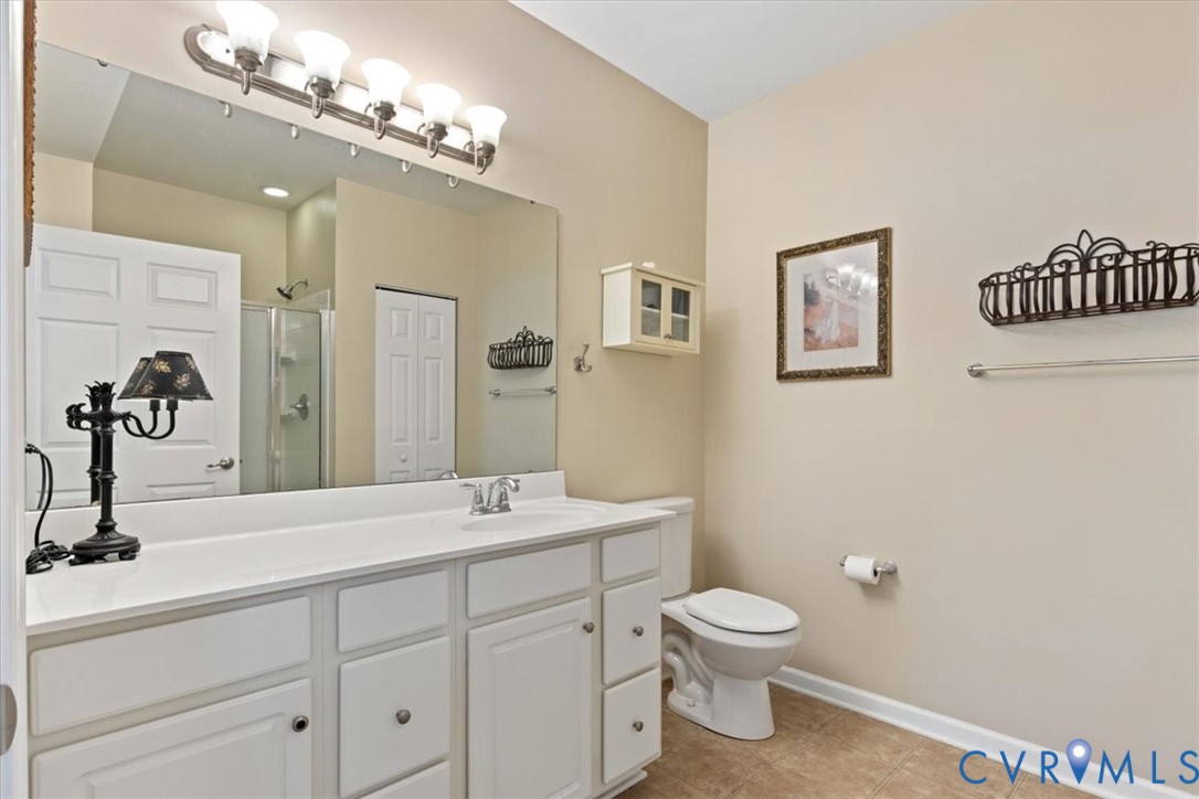 14011 Briars Circle, Unit 104 Midlothian, VA 23114 - Photo 17 of 22 a bathroom with a toilet a sink and mirror