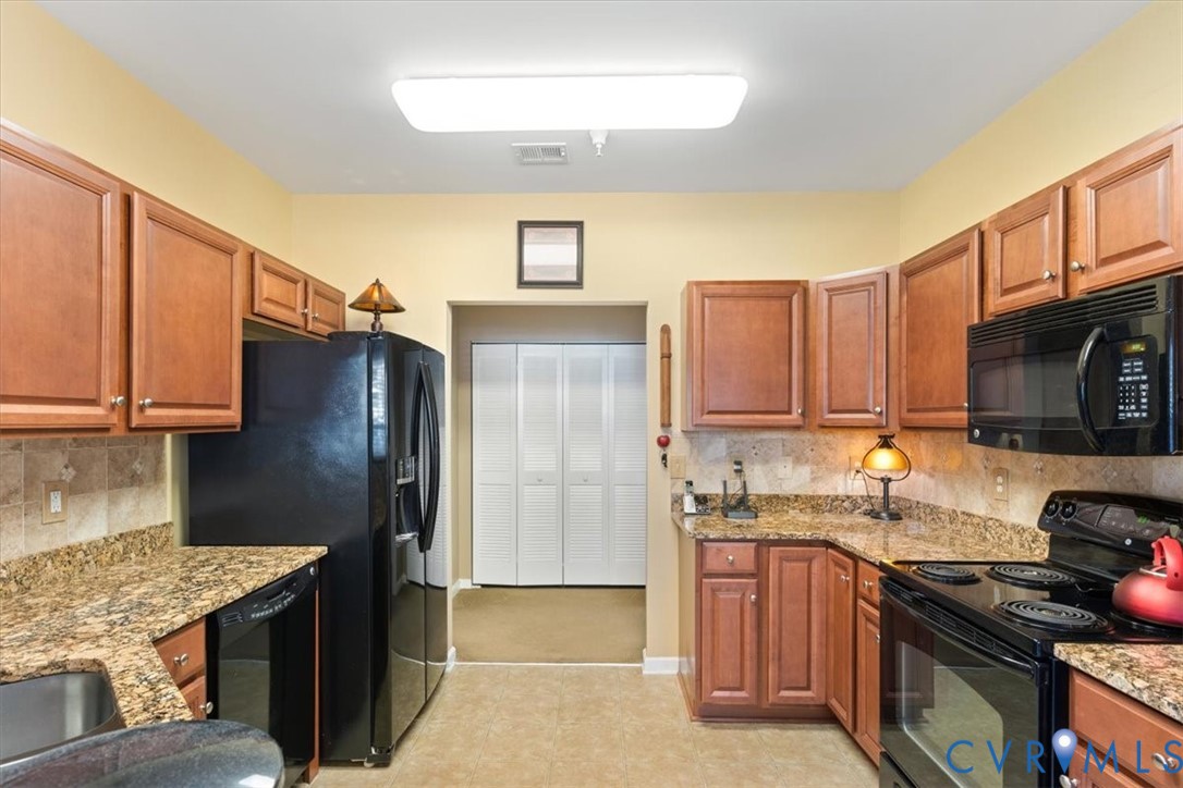 14011 Briars Circle, Unit 104 Midlothian, VA 23114 - Photo 4 of 22 a kitchen with stainless steel appliances granite countertop a stove refrigerator sink and microwave