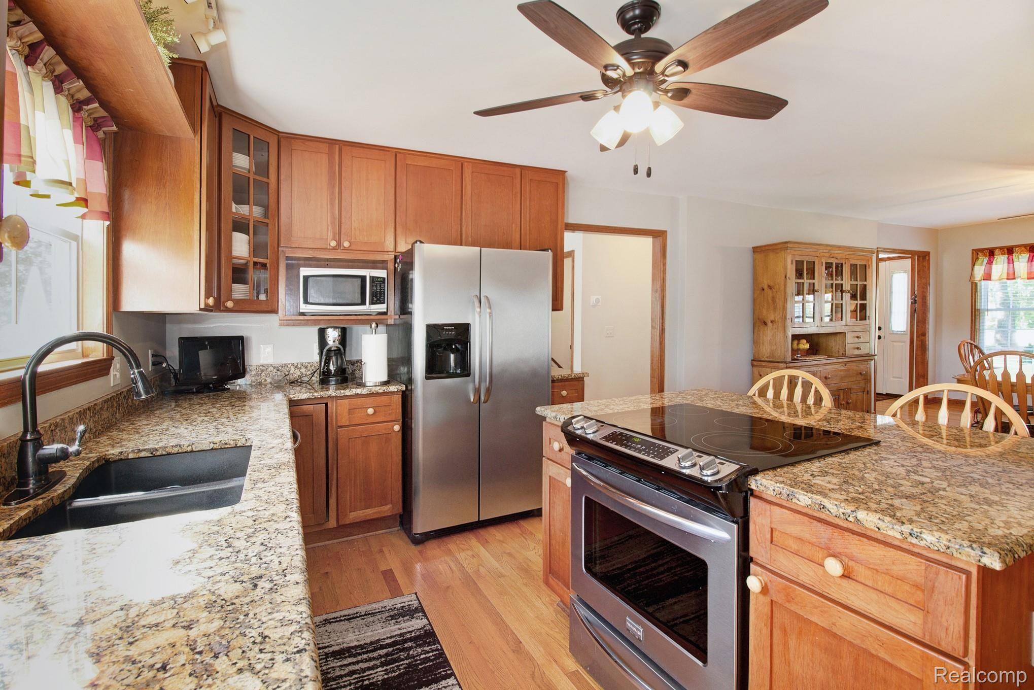Kitchen has granite counter tops, stainless steel appliances and wood floors