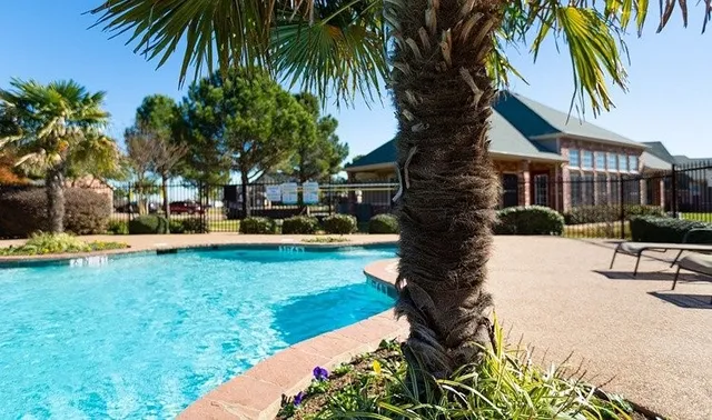 a front view of a house with garden and trees