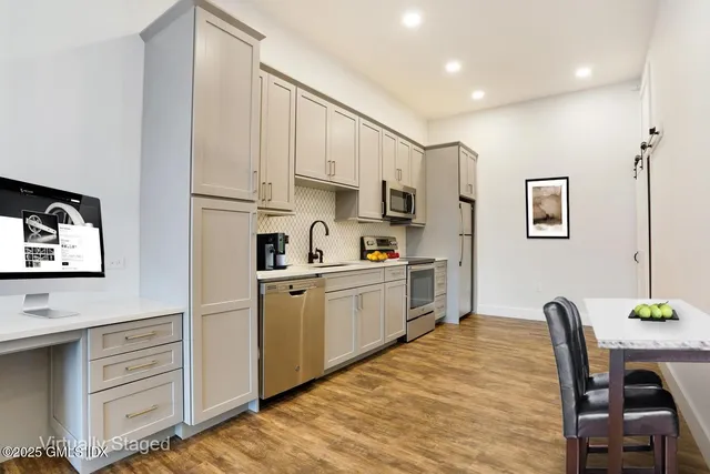 a kitchen with cabinets and wooden floor