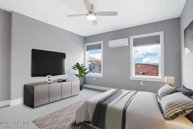 a bedroom with a balcony a bed and a flat screen tv