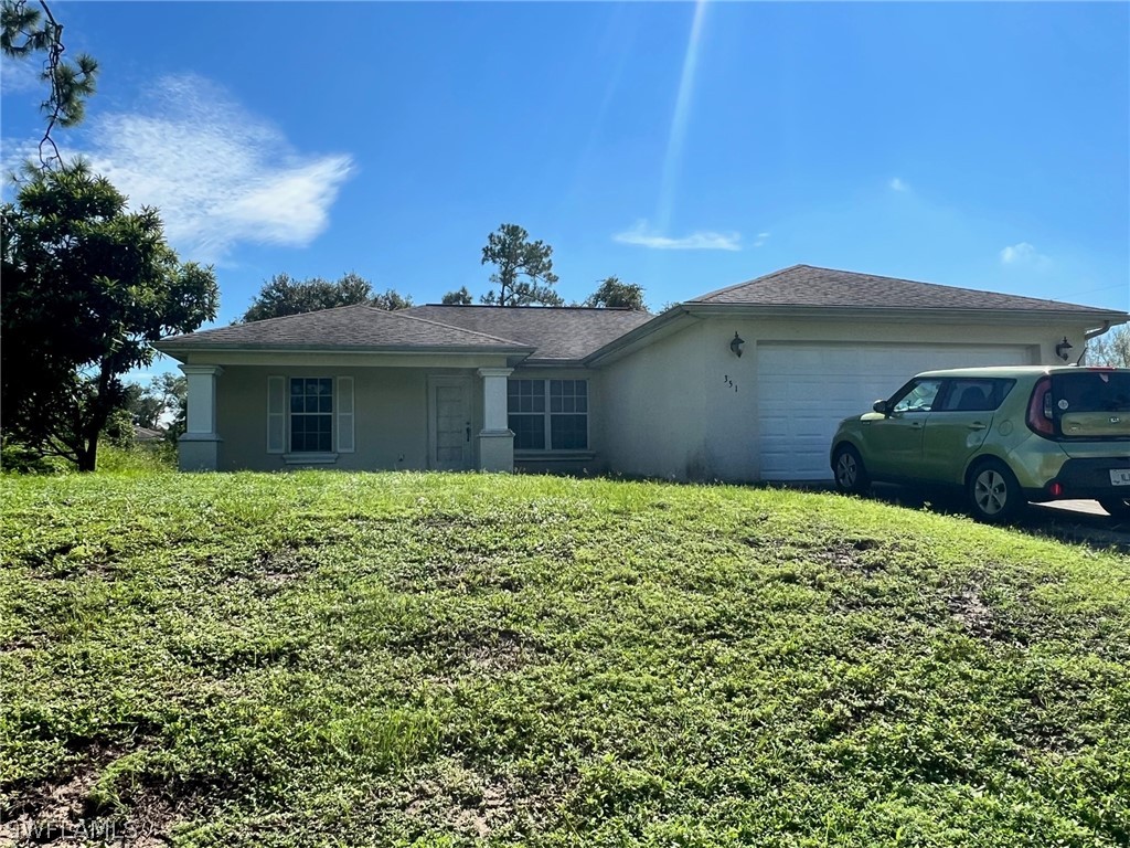 351 Ranch Avenue Lehigh Acres, FL 33974 - Photo 1 of 13 a front view of a house with a garden