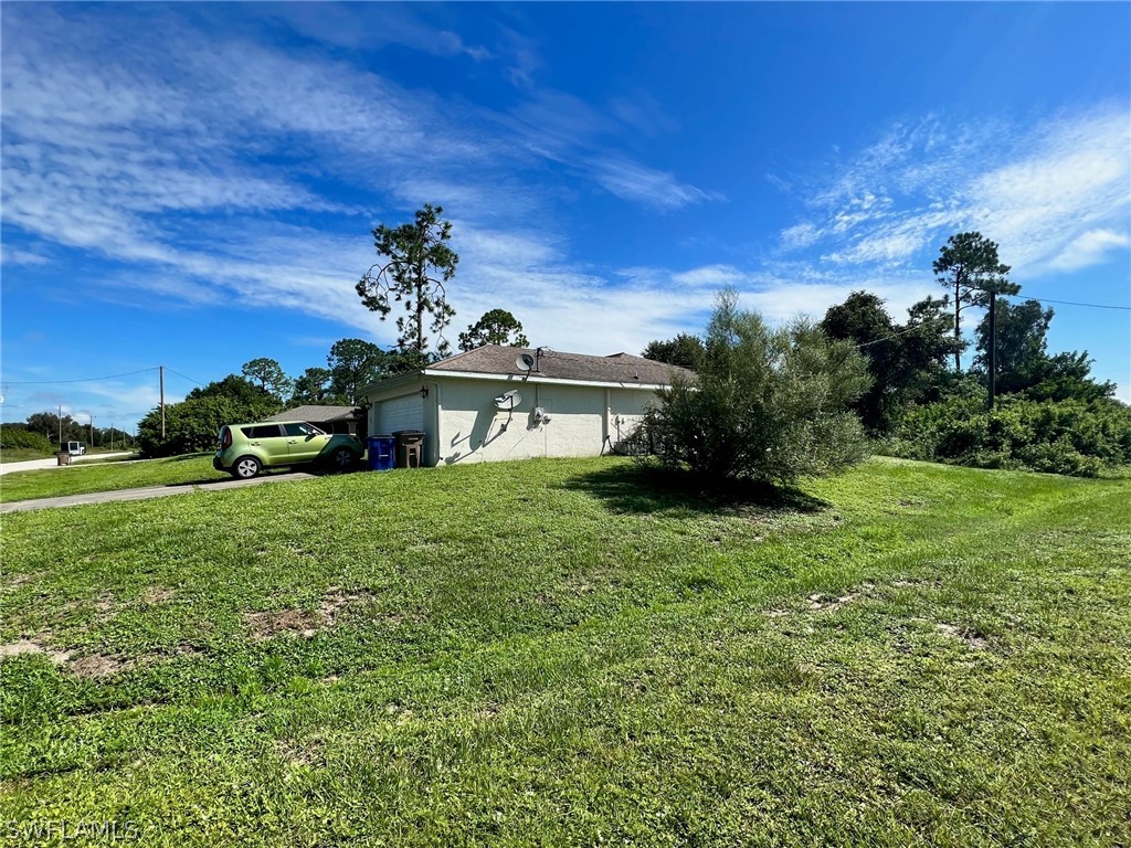 351 Ranch Avenue Lehigh Acres, FL 33974 - Photo 2 of 13 a view of a house with a garden