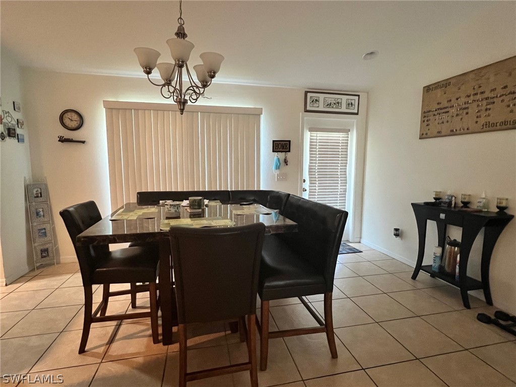 351 Ranch Avenue Lehigh Acres, FL 33974 - Photo 7 of 13 a view of a dining room furniture and chandelier