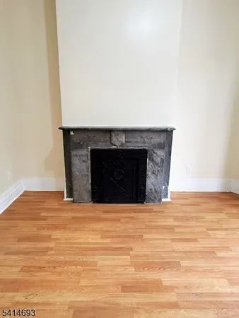 a view of empty room with wooden floor and fireplace
