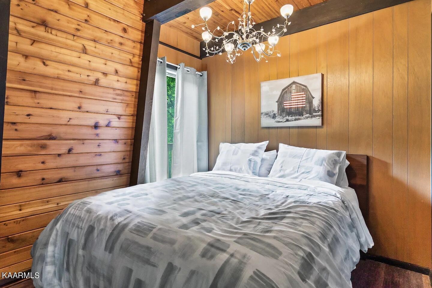 1424 Zurich Road Gatlinburg, TN 37738 - Photo 21 of 27 a bedroom with a bed and a chandelier