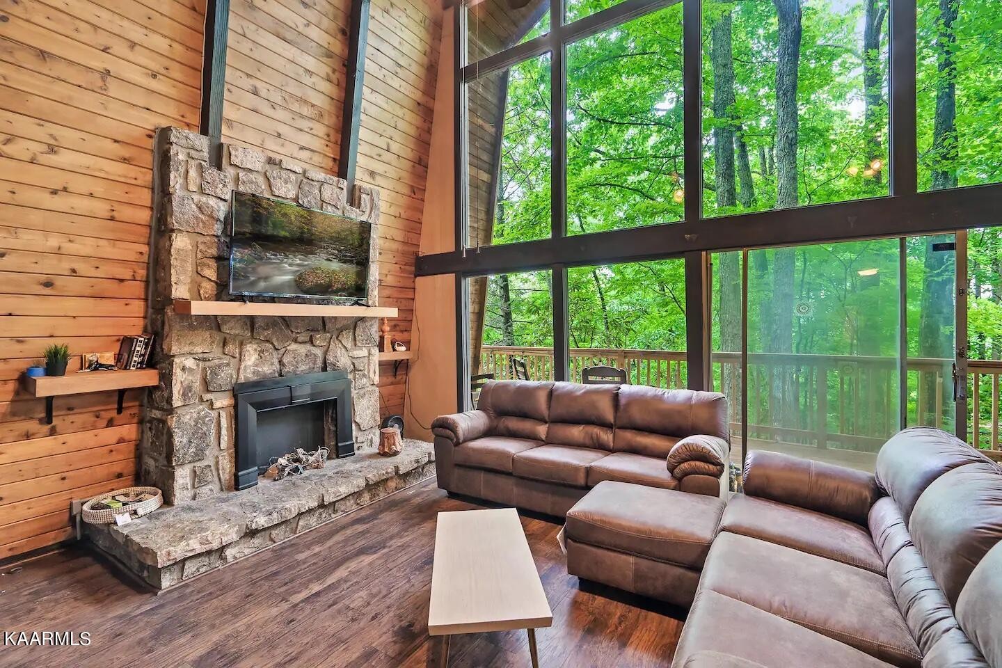1424 Zurich Road Gatlinburg, TN 37738 - Photo 5 of 27 a living room with furniture a fireplace and a floor to ceiling window